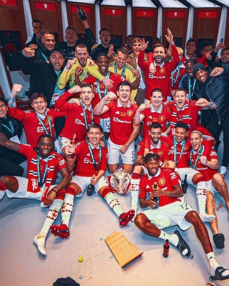 the manchester united team celebrate with their trophy