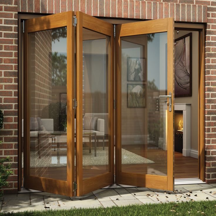 an open patio door on the side of a brick building with glass doors and windows