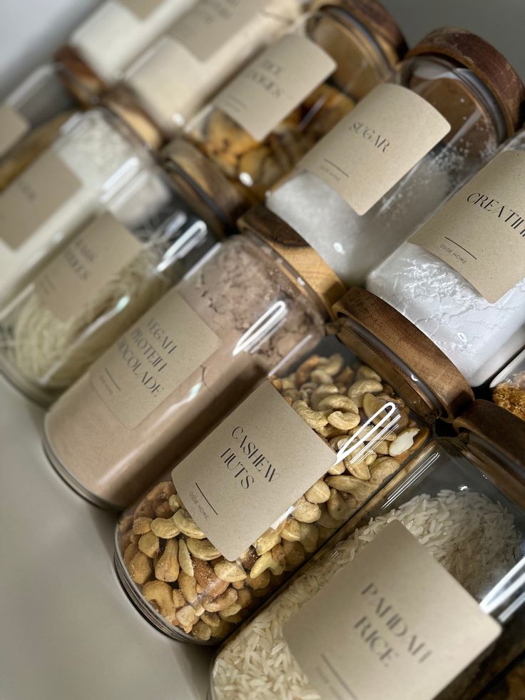 several jars filled with different types of nuts and seeds, all labeled with labels on them