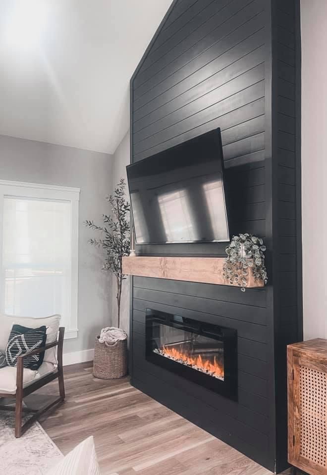 a living room with a fireplace and tv mounted on the wall