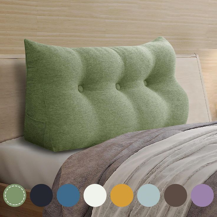 there is a bed with green pillows on it and many different colors around the headboard