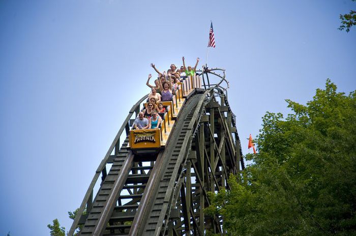 people are riding on the roller coaster at an amusement park