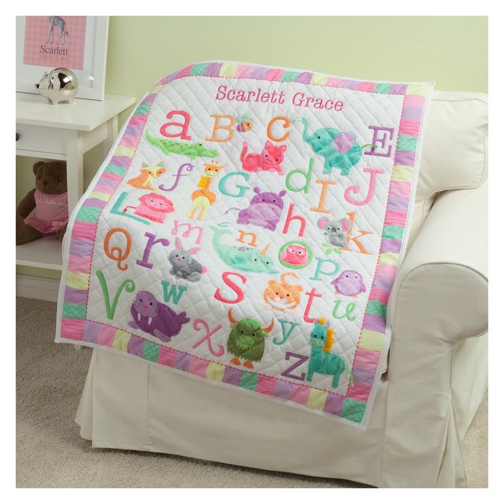 a child's bed with a personalized quilt on it