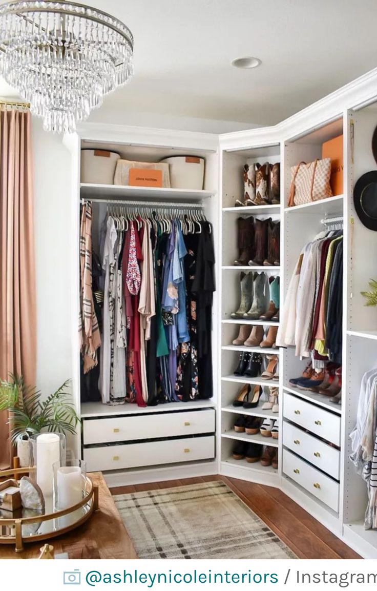 an organized closet with clothes, shoes and other items on shelves in front of a chandelier