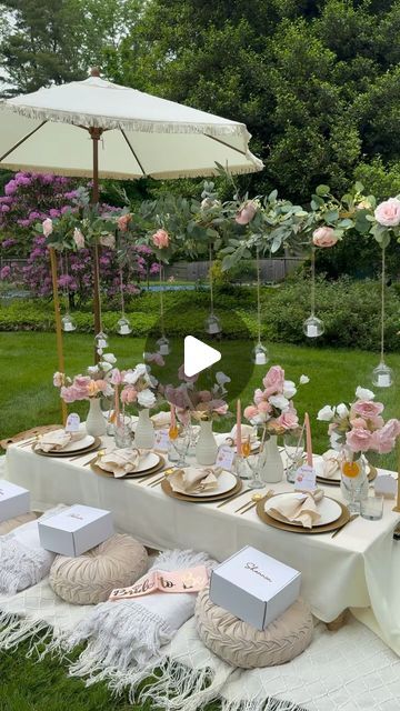 a table set up for a wedding with pink flowers and white napkins on it