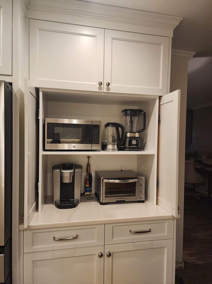 a kitchen with white cupboards and appliances on top of it's counter tops