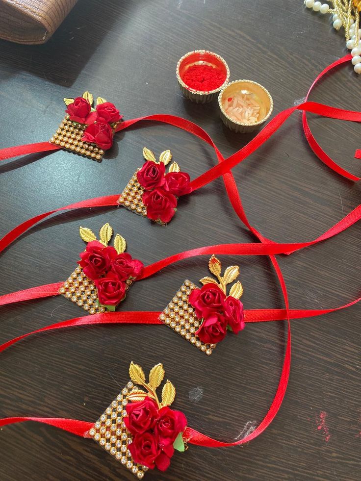 some red roses are tied to ribbons on a table with other items around them and sitting on the table