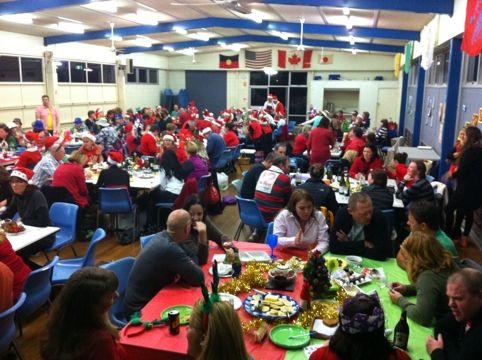 a large group of people sitting at tables eating food