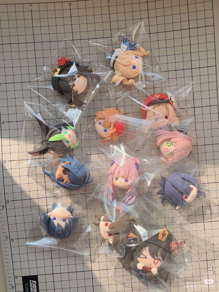 a bunch of anime figurines sitting on top of a plastic bag next to each other