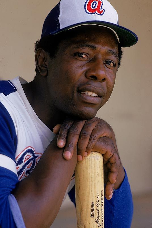 a close up of a baseball player wearing a hat and posing for a photo with his bat