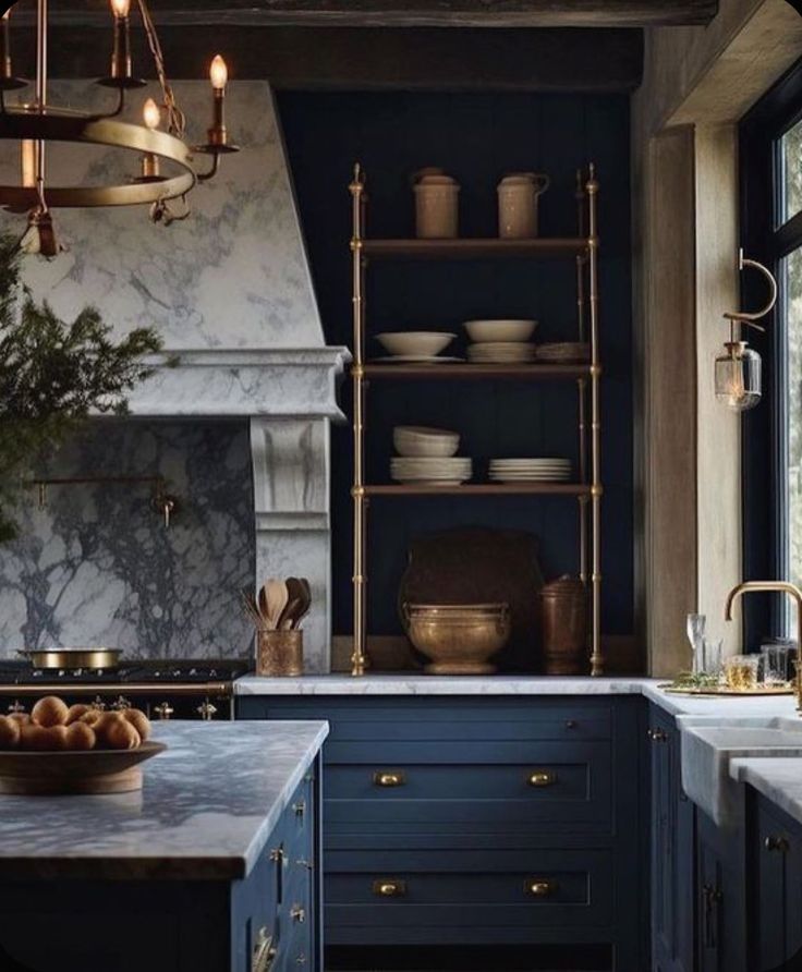 a kitchen with blue cabinets and marble counter tops, gold accents on the shelves and brass fixtures