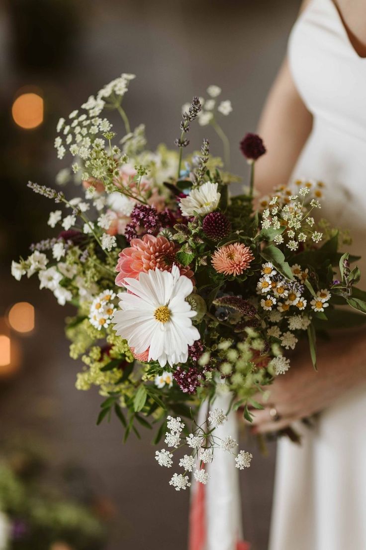 a woman holding a bouquet of flowers in her hands