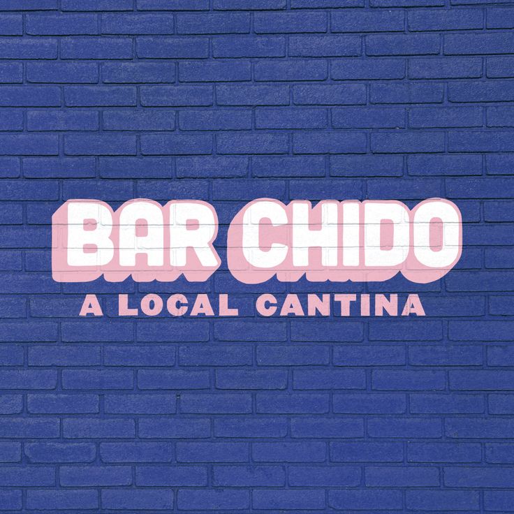 a blue brick wall with the words bar chido in pink and white on it