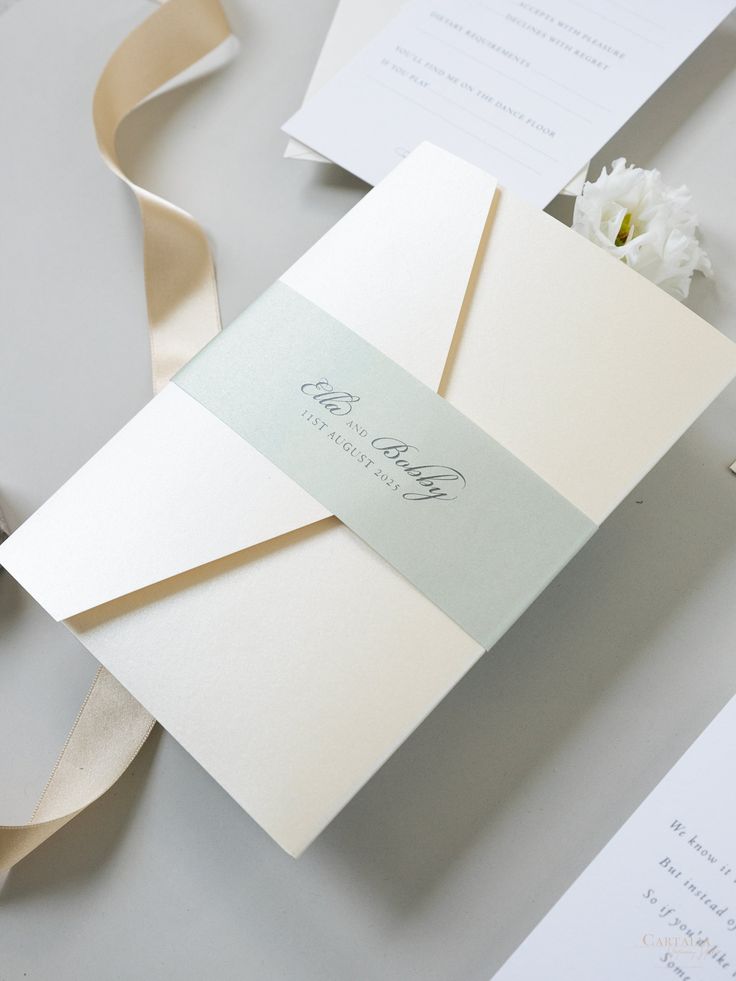 the wedding stationery is laid out on top of each other