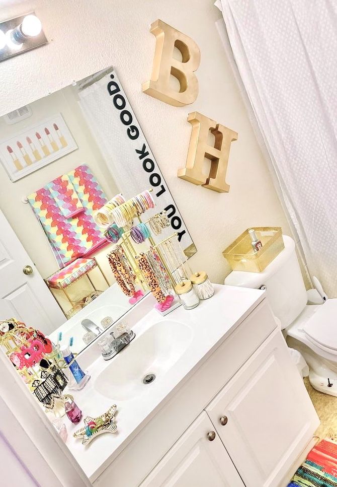 the bathroom is decorated in bright colors and has gold letters on the wall above the sink