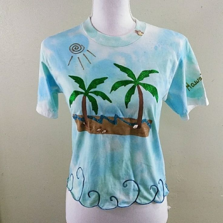 Hand Painted One-Of-A-Kind Tropical T-Shirt S When I Lived In Hawaii I Sold My One-Of-A-Kind T-Shirts At A Gift Shop In The King Kamehameha Hotel, And Recently Came Across A Few I Had Left. This One Measures Approx. 17" From Armpit To Armpit And Is About 19" In Length. I'd Recommend Hand Washing Because It's Decorated With Real Seashells. Note: Hand Painted; Imperfections Are A Part Of The Uniqueness Of The Top. Price Firm! A Lot Of Work Went Into This, And It's Already Discounted. Tie Dye Short Sleeve Vacation Top, Tie Dye Short Sleeve Top For Vacation, Tie Dye Short Sleeve Top For Beach, Blue Cotton T-shirt For Beach Season, Blue Short Sleeve T-shirt For Beach Season, Blue Short Sleeve T-shirt For Beach, Blue Short Sleeve Summer T-shirt, Light Blue Short Sleeve Tops For Beach Season, Blue Crew Neck Summer Top