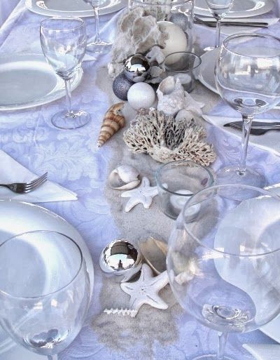 the table is set with silverware and seashells for an ocean themed dinner