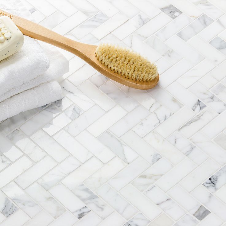 a wooden toothbrush sitting on top of towels next to a pile of folded white towels