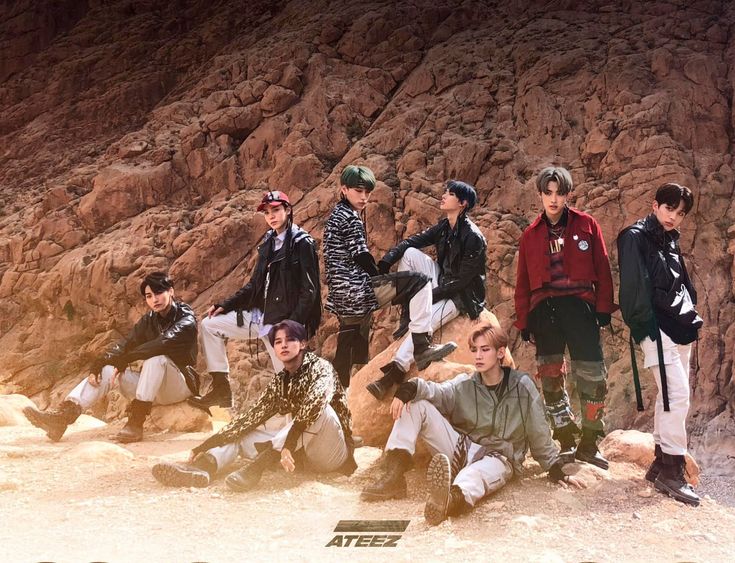 a group of young men standing next to each other on top of a rocky hillside