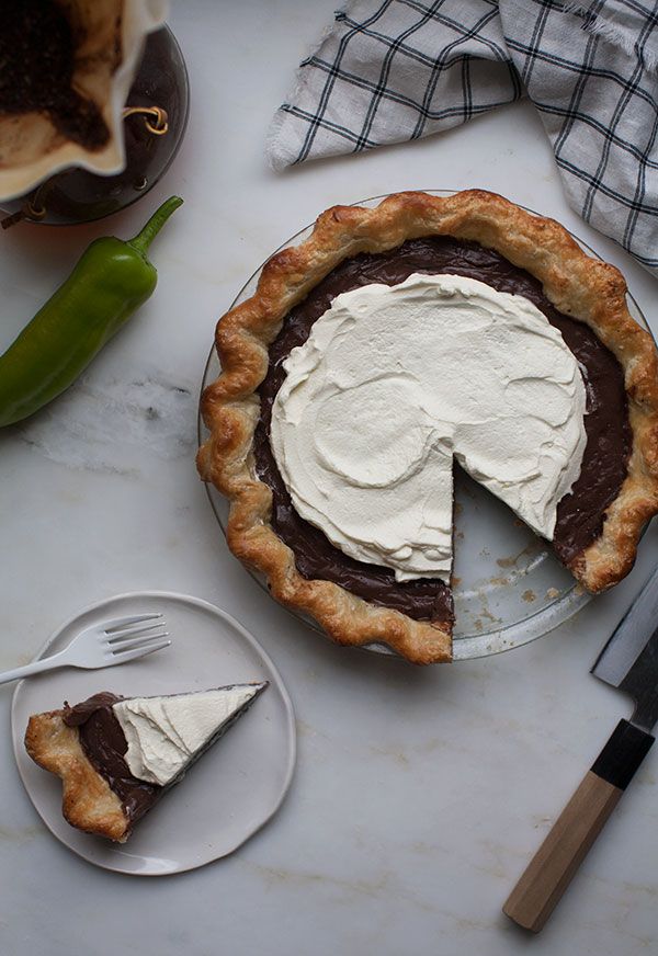 there is a pie with white frosting on it and a knife next to it