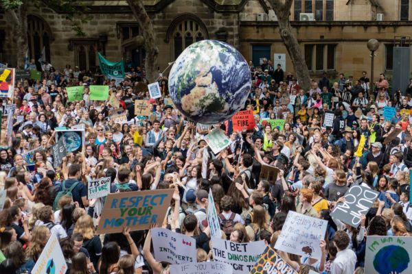 a large group of people holding signs and balloons