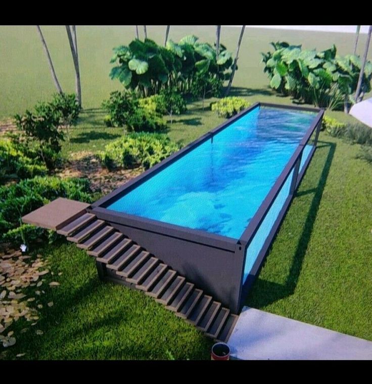 an empty swimming pool in the middle of some grass