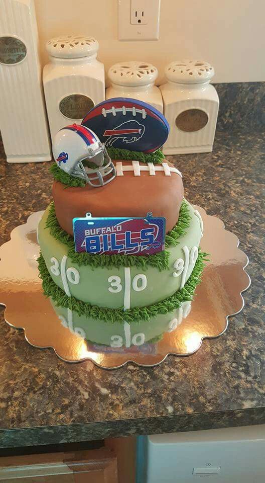 a three tiered cake is decorated with footballs and helmets on top of each other