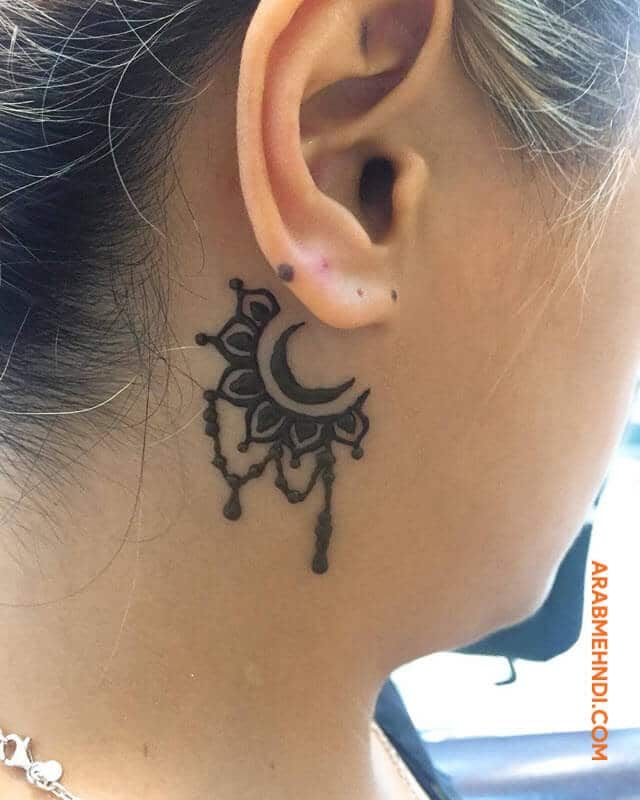 a woman with a tattoo on her neck and behind the ear is a crescent moon