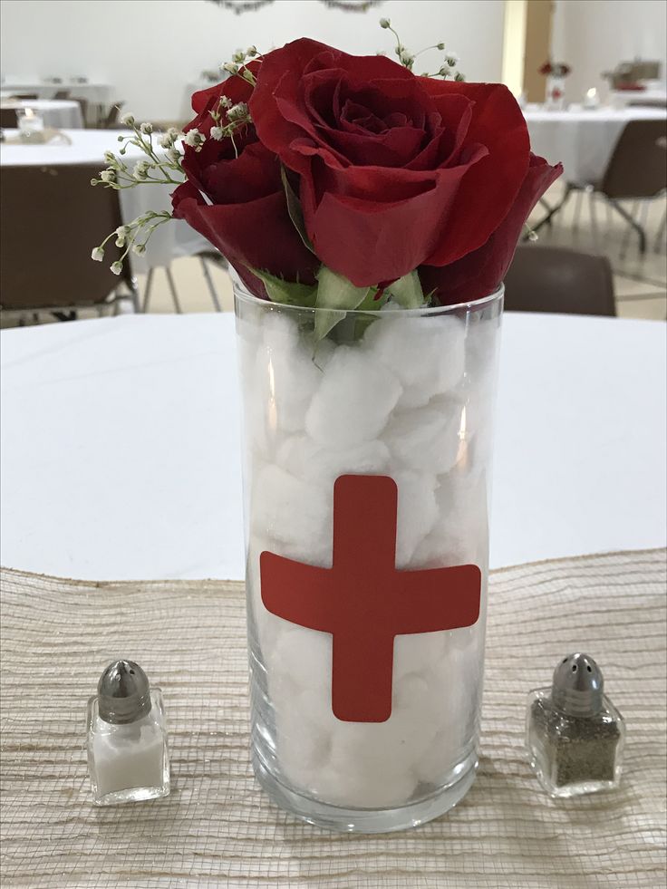 a glass vase filled with marshmallows and a red cross