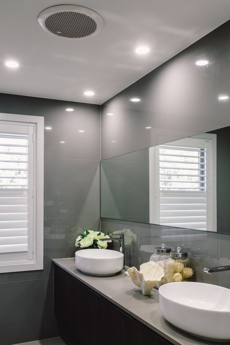 a bathroom with two sinks and a large mirror above it's countertop, along with shuttered windows