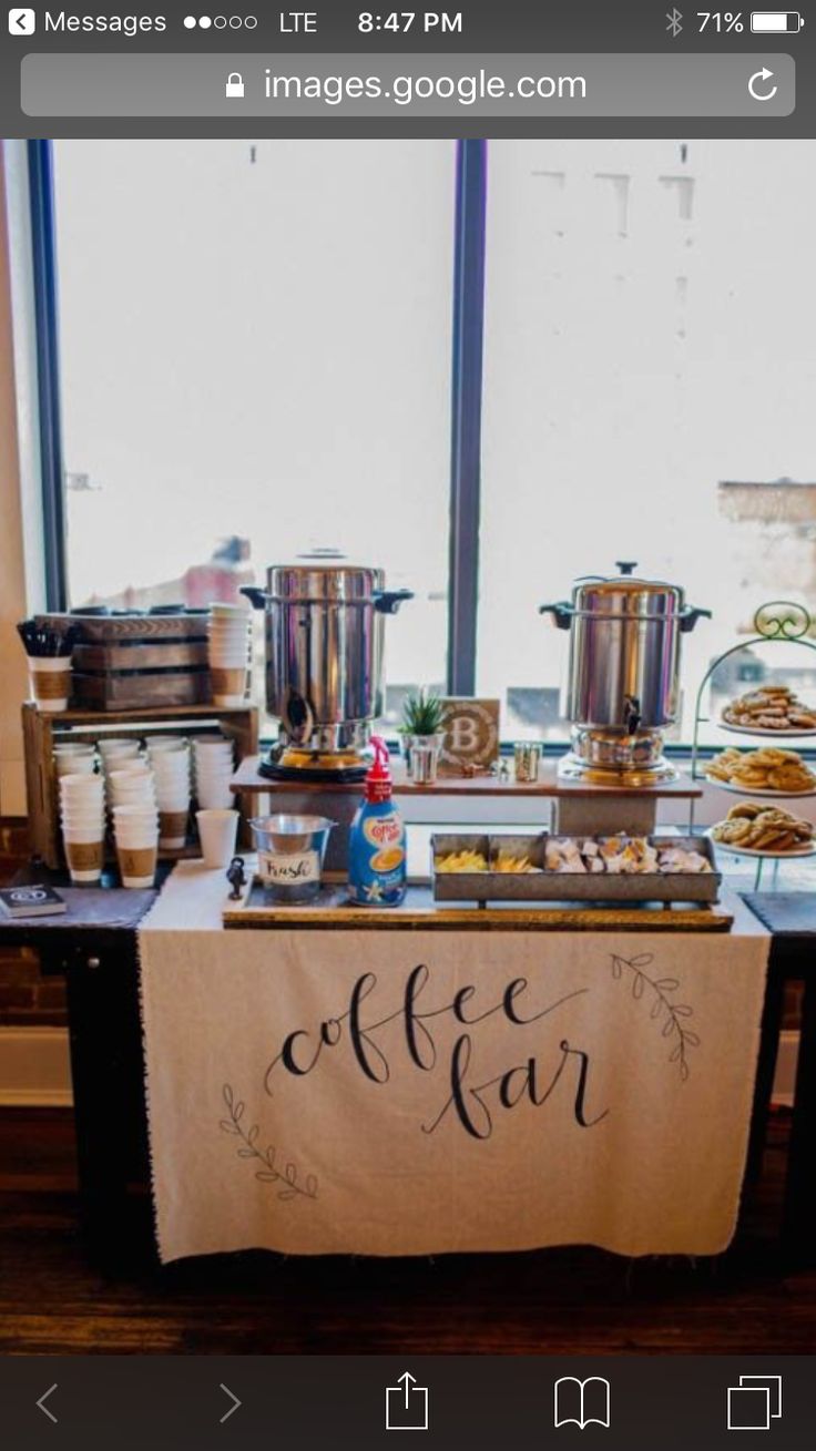 a table with coffee and pastries on it in front of a window that says coffee bar