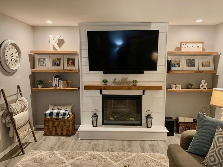 a living room with a large flat screen tv mounted on the wall above a fireplace