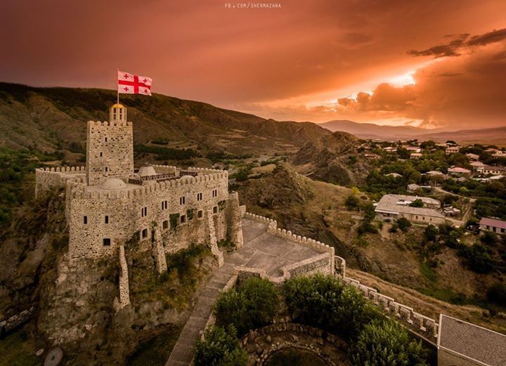 an aerial view of a castle with a flag on top