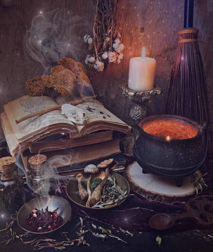 an open book sitting on top of a table next to candles and other items in bowls