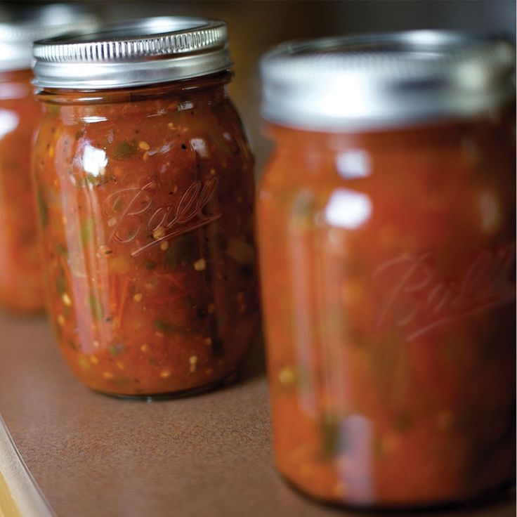 three jars filled with food sitting on top of a counter