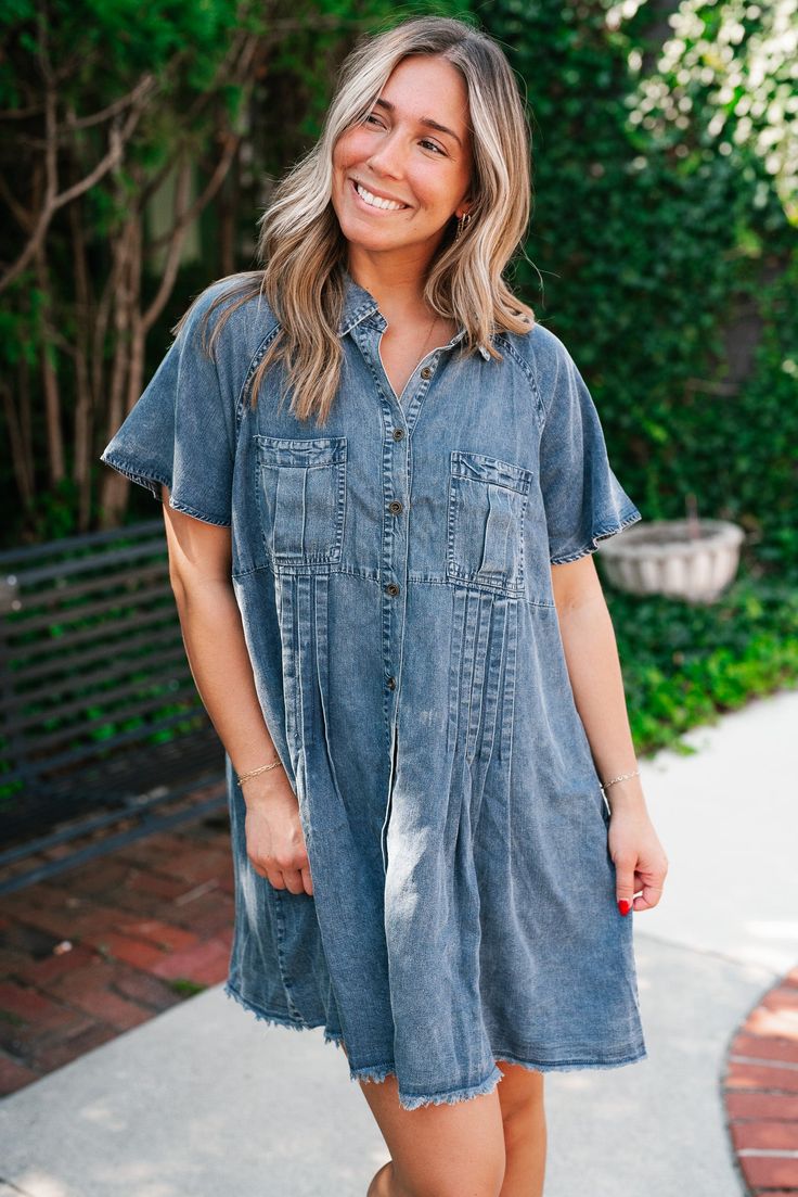 Make a lasting statement with the First Impression Frayed Hem Denim Dress, a perfect blend of casual chic and timeless elegance. This dress features a classic collared neckline, exuding a sophisticated yet laid-back vibe that effortlessly transitions from day to night. The front pockets add a functional and stylish touch, while the subtle pleated detailing cascading from the pockets introduces a hint of texture and movement. The frayed hemline offers a playful edge, bringing a modern twist to th Medium Wash Button-up Dress For Daywear, Relaxed Fit Chambray Denim Dress In Medium Wash, Relaxed Fit Chambray Denim Dress, Summer Denim Washed Shirt Dress, Relaxed Fit Denim Blue Chambray Dress, Chambray Denim Dress With Relaxed Fit, Chic Denim Blue Shirt Dress For Work, Washed Denim Top For Work, Classic Medium Wash Denim Top For Summer