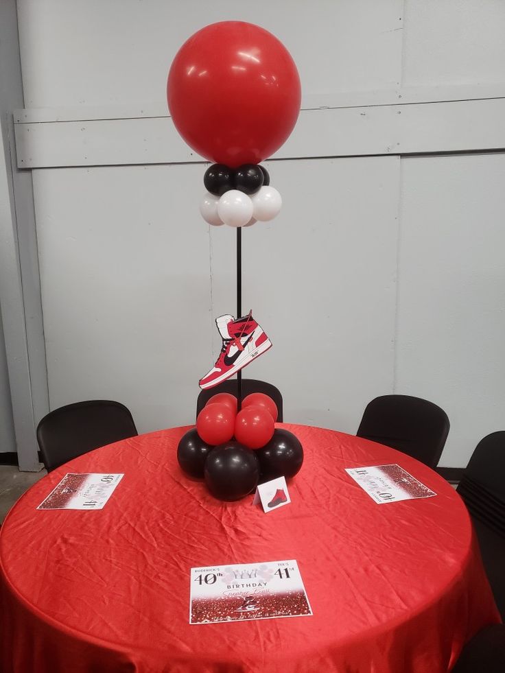 a red table with black and white balloons