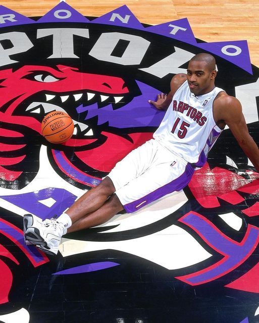 a man sitting on top of a basketball court next to a dragon logo wallpaper