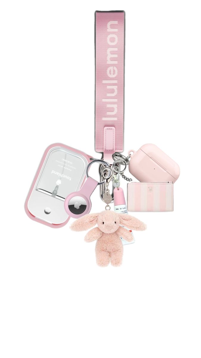 a pink keychain with a stuffed animal on it and other items attached to it