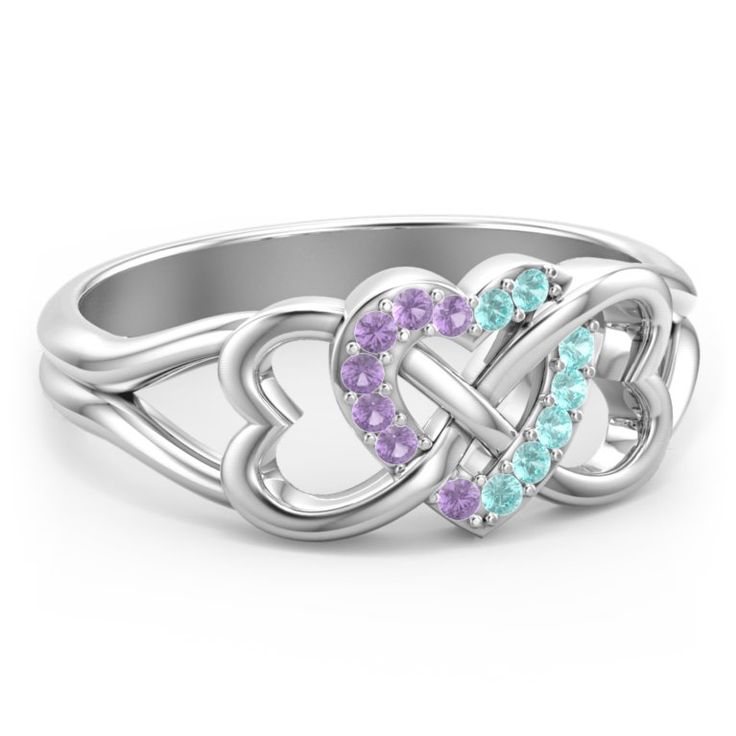 a white gold ring with two hearts in the middle and diamonds on each side,