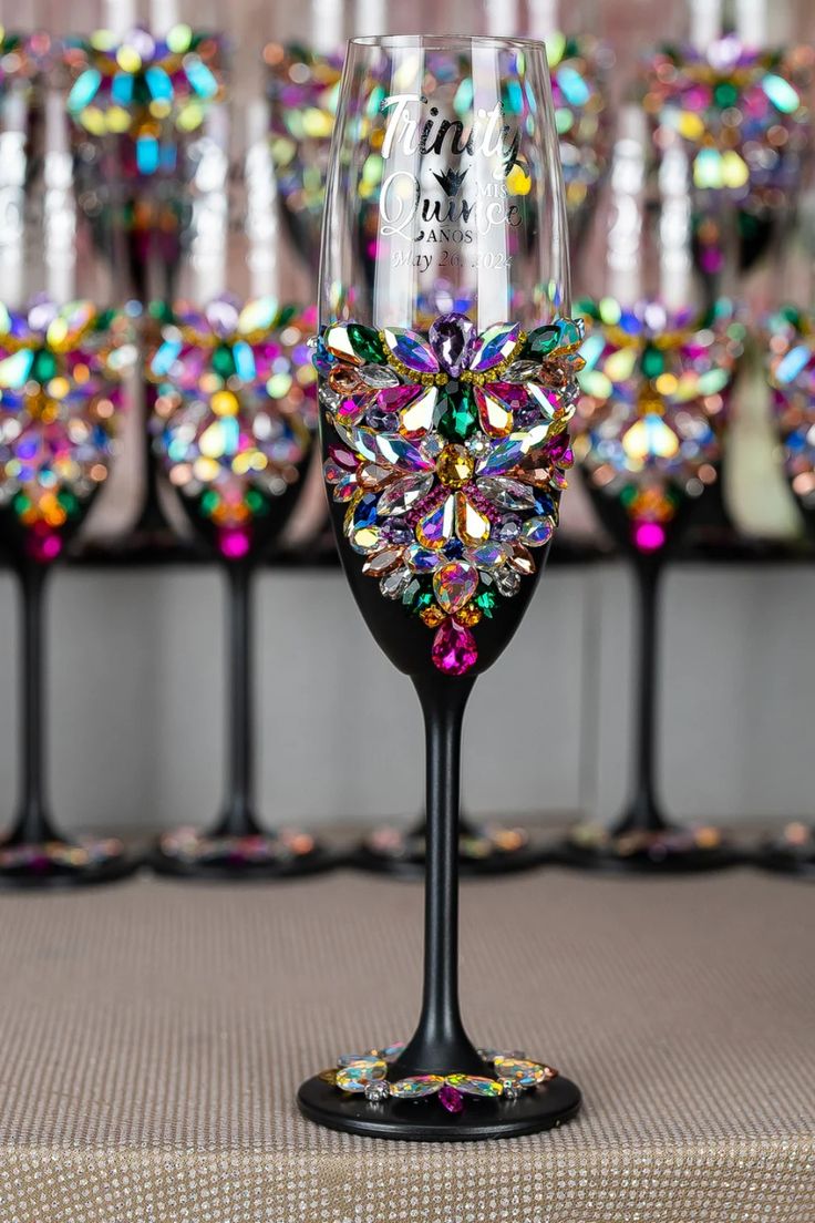 a wine glass sitting on top of a table next to other glasses in the background