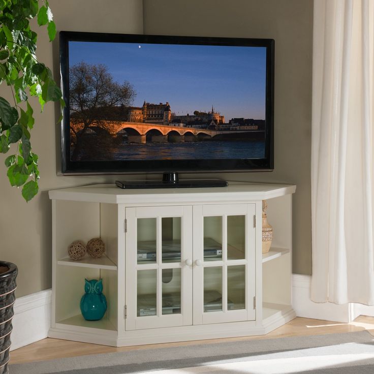 a flat screen tv sitting on top of a white cabinet