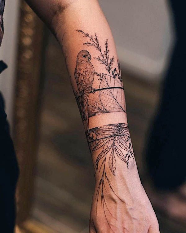 a woman's arm with a bird and flower tattoo on the left hand, next to a mirror