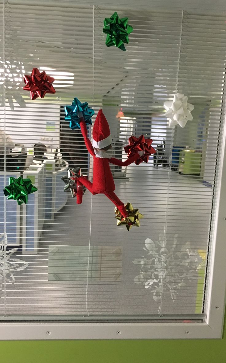 an office cubicle decorated with christmas decorations and paper stars hanging from the window sill