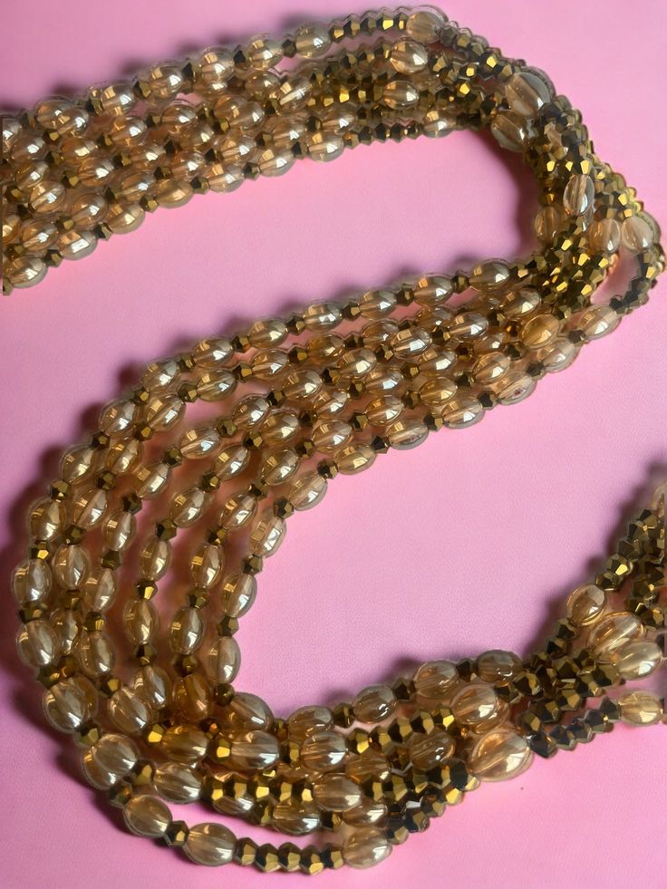 Double Strand Waist Bead "Tiassalé" is versatile and can be worn for any occasion, be it casual or formal. Its exquisite design will elevate your outfit and make you stand out from the crowd. It can also be worn underneath clothing, making it a discreet and elegant way to add a pop of color and culture to your everyday look. Our waist bead is the perfect choice for anyone looking for a stylish and meaningful accessory. It is handmade with love and care in Ivory Coast, using the highest quality m Clothing Making, Ivory Coast, Spring Sale, Exquisite Design, Handmade With Love, Pop Of Color, Free Gifts, Beads, Gold