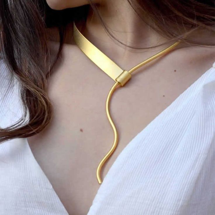 Made in NY Like the magic heroine, Antigone, this necklace is everything but evanescent. A rhythmic forged brass metal forged necklace resembling a pendant. Its seemingly enticing flow, hug and accentuate the next. Pair it with the Antigone ring and bracelet. Platings: Gold: 18k electroplated gold Silver: Plated with pure silver and Oxidized to give an antique look.Size: Length 9.2" Nickel-Free Modern Twist Brass Jewelry In Gold Color, Modern Twist Gold Brass Jewelry, Modern Twist Metal Jewelry For Party, Gold Jewelry With A Modern Twist For Party, Modern Metal Jewelry For Party, Modern Twist Gold Jewelry For Party, Elegant Brass Necklaces With Unique Variations, Elegant Brass Necklace With Unique Variations, Hand Forged Metal Choker Necklace