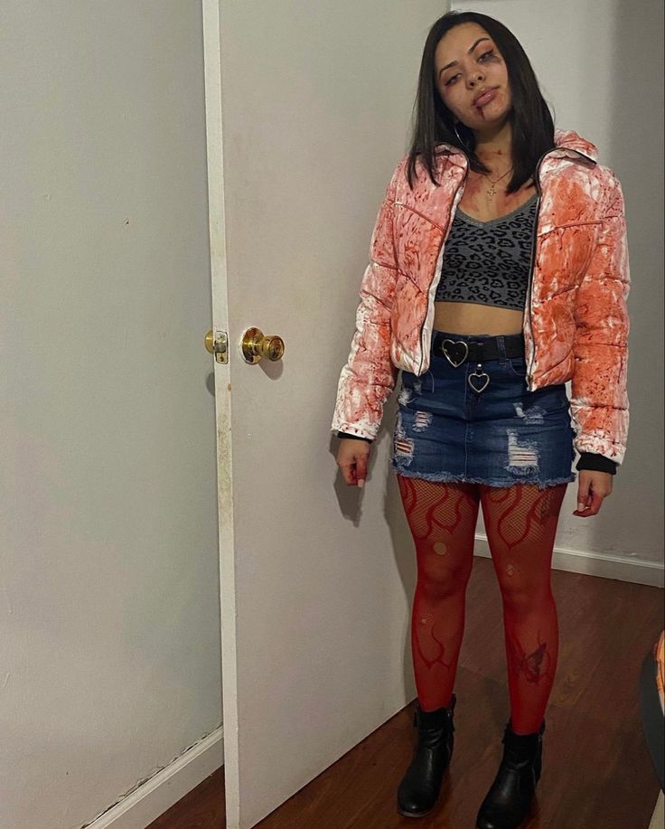 a young woman standing in front of a door wearing red tights and an orange jacket