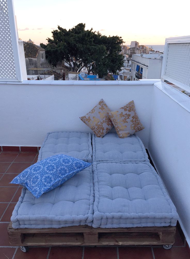 a couch made out of pallets on top of a roof