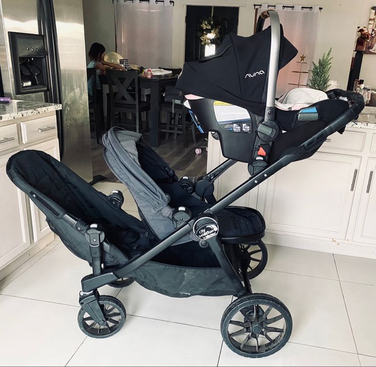 a baby stroller in the middle of a kitchen with an umbrella on it's side