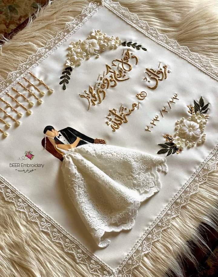 a wedding embroidered on a white pillow with the words happy anniversary written in cursive writing